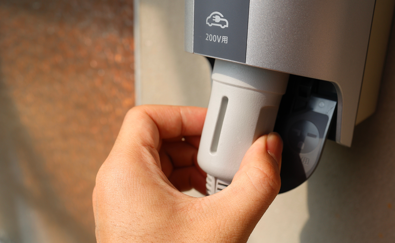 EV用200V充電コンセントにプラグを接続する様子